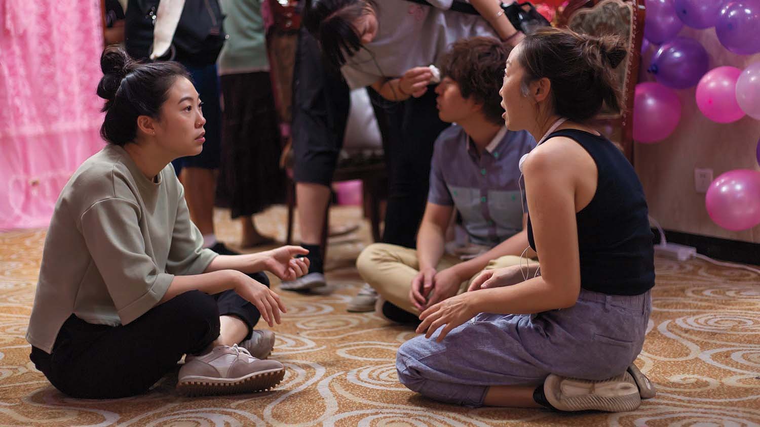 Nữ diễn viên đối thoại với đạo diễn Lulu Wang (phải) trên phim trường. Ảnh: A24